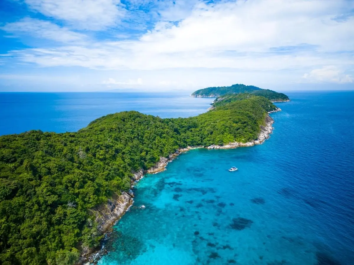 Aerial view of a green Racha island beside a turquoise coral reef