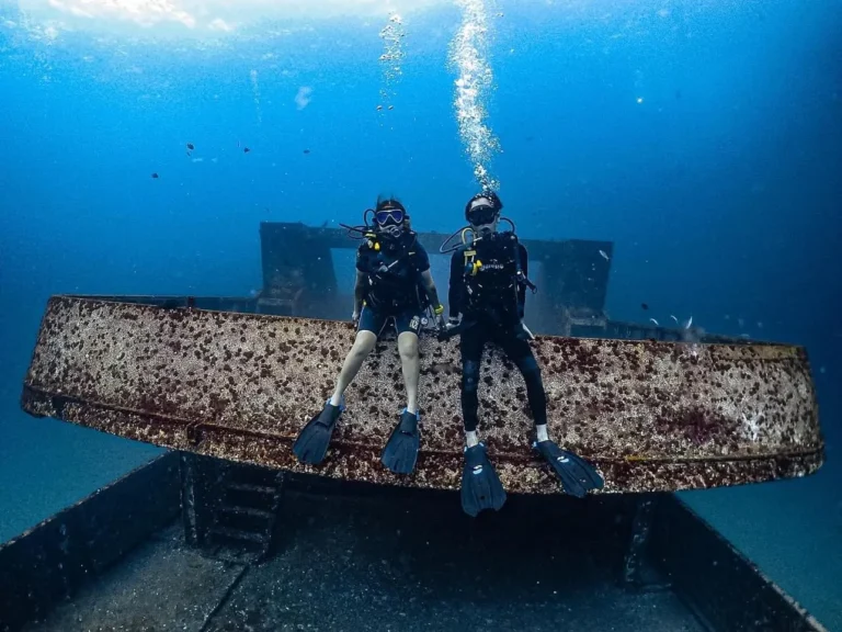 scuba dive Phuket Certified divers scuba diving at Racha Islands Phuket with coral reefs and clear visibility