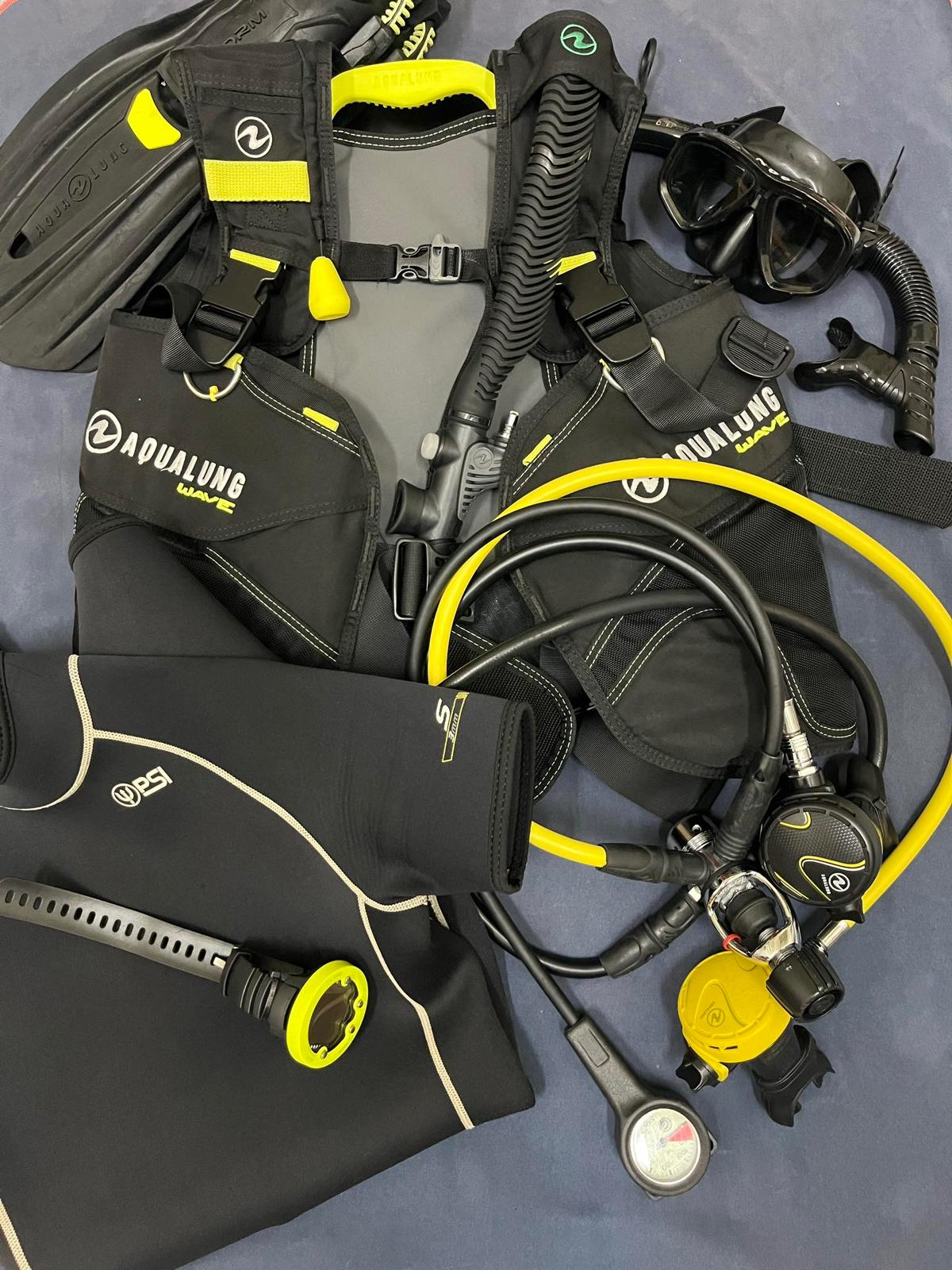 A set of professional scuba diving gear, including regulators, wetsuits, and BCDs, used for diving trips