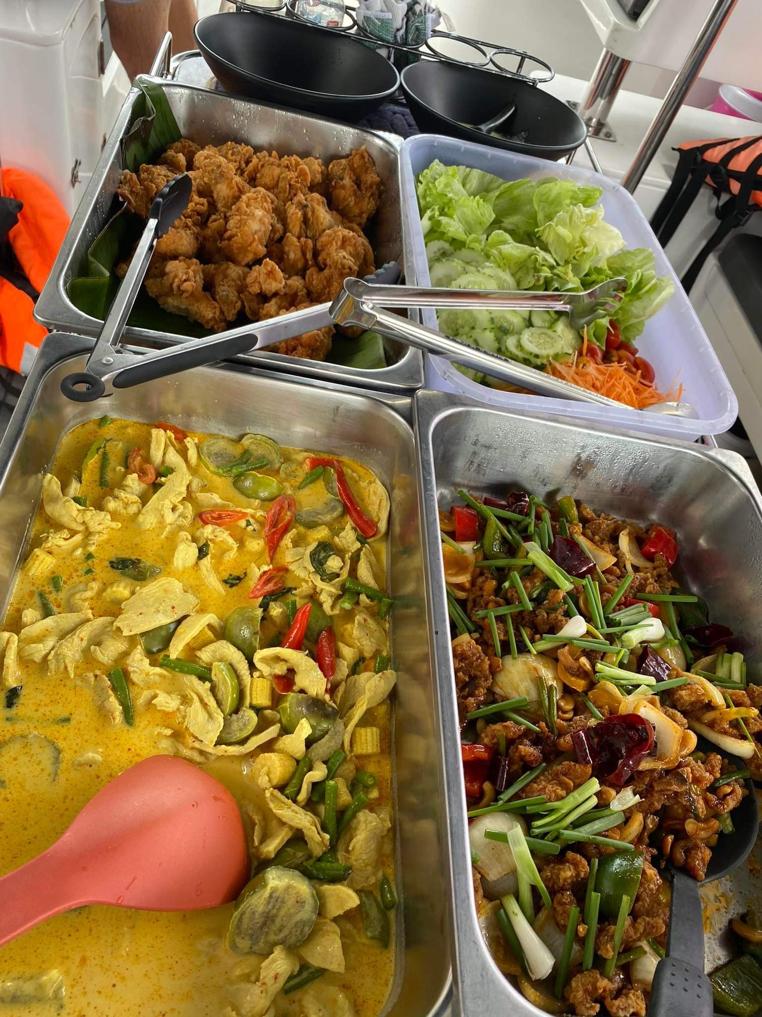 Thai lunch buffet with curry, chicken, vegetables and salad aboard the private boat